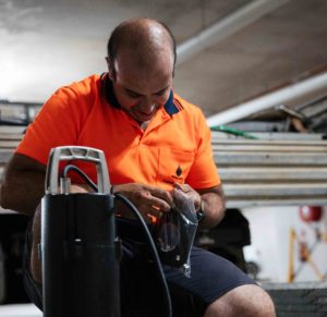 Technician servicing a rainwater tank pump