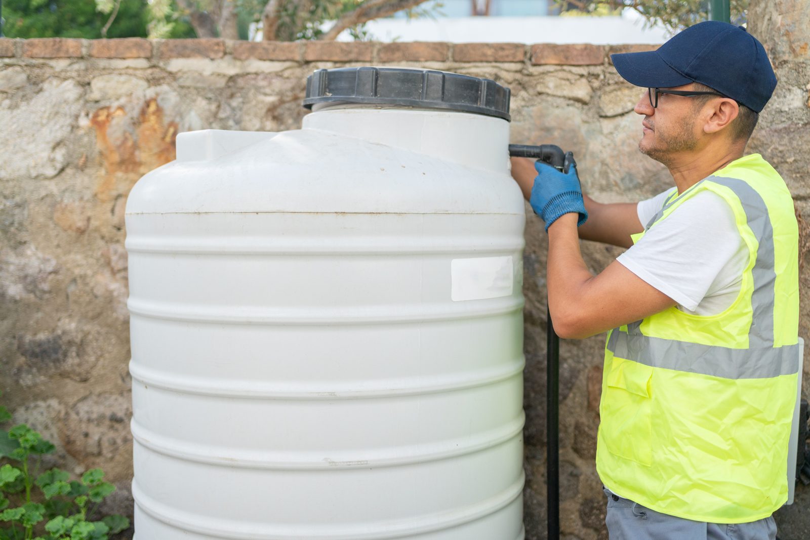 Technician welding a repair on a white plastic water tank